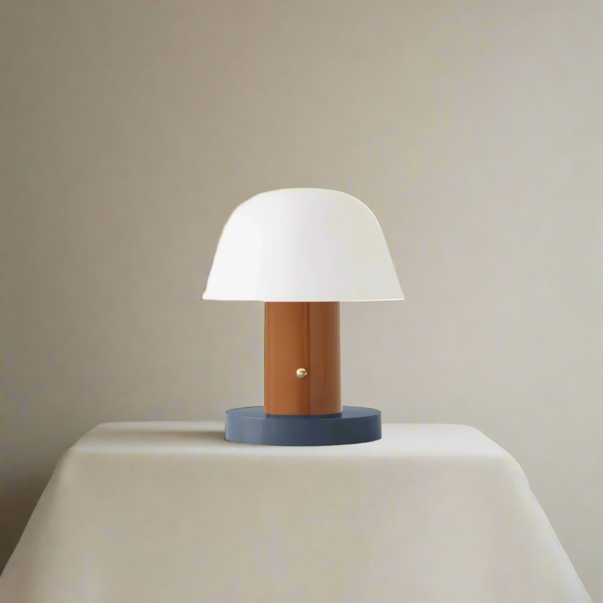Table lamp with white shade, wooden base, and blue skirt on a beige background