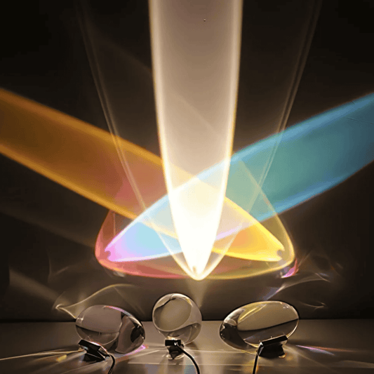 Colorful light beams emanating from a transparent cone with three metallic objects below on a dark background.