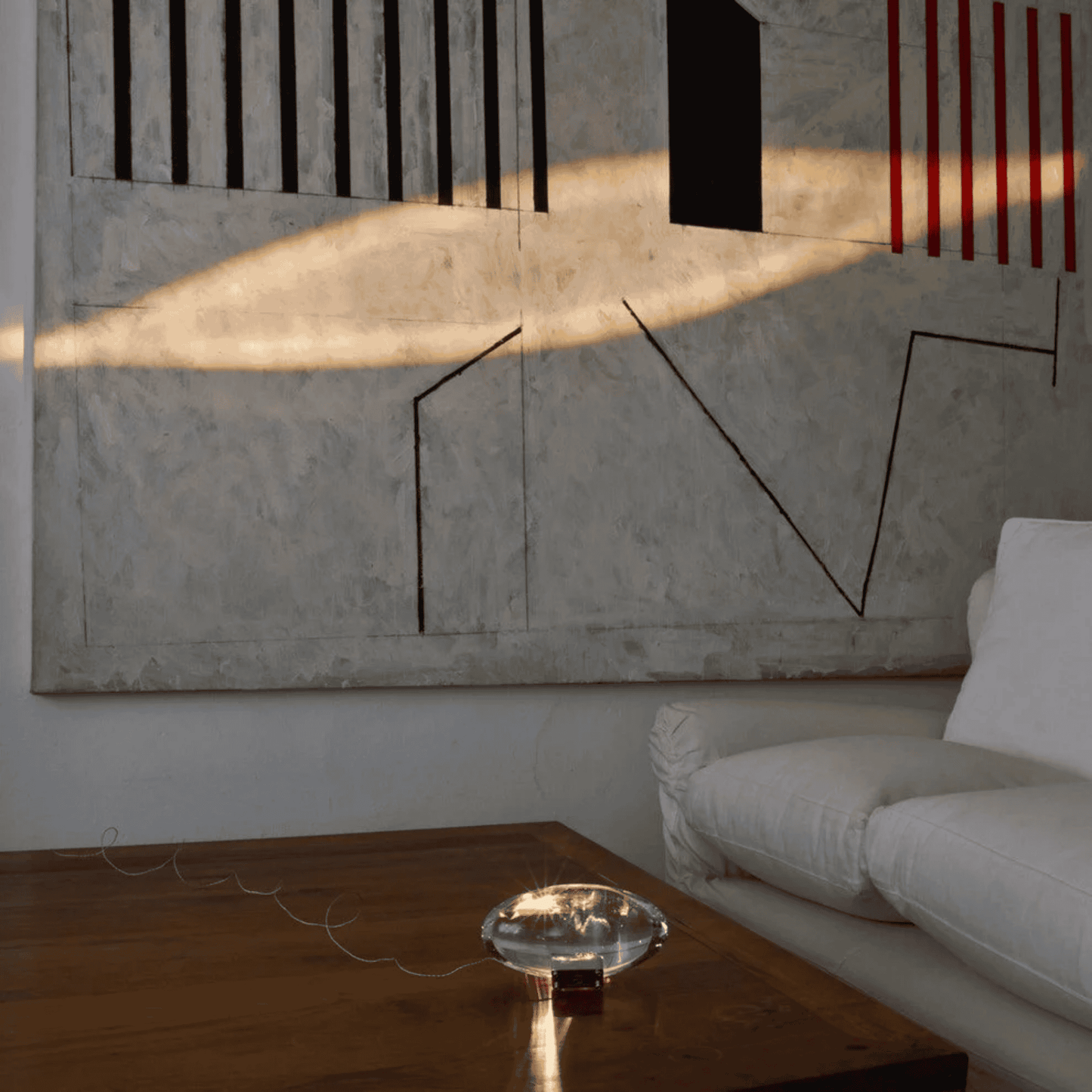 Modern living room with abstract art on the wall and a white sofa.