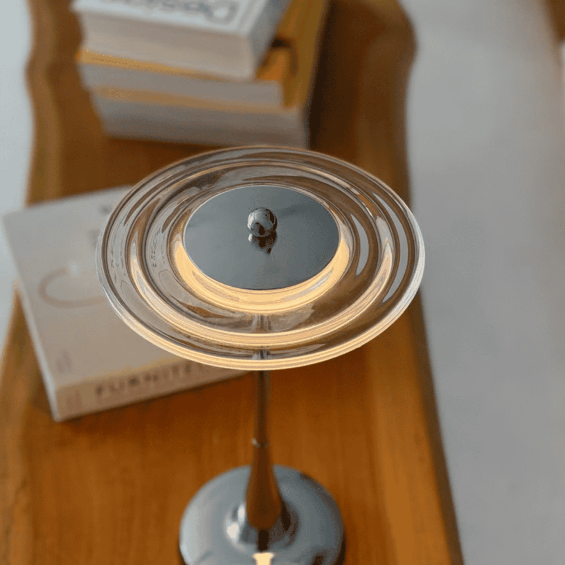 Close-up of a decorative item on a wooden surface with books in the background