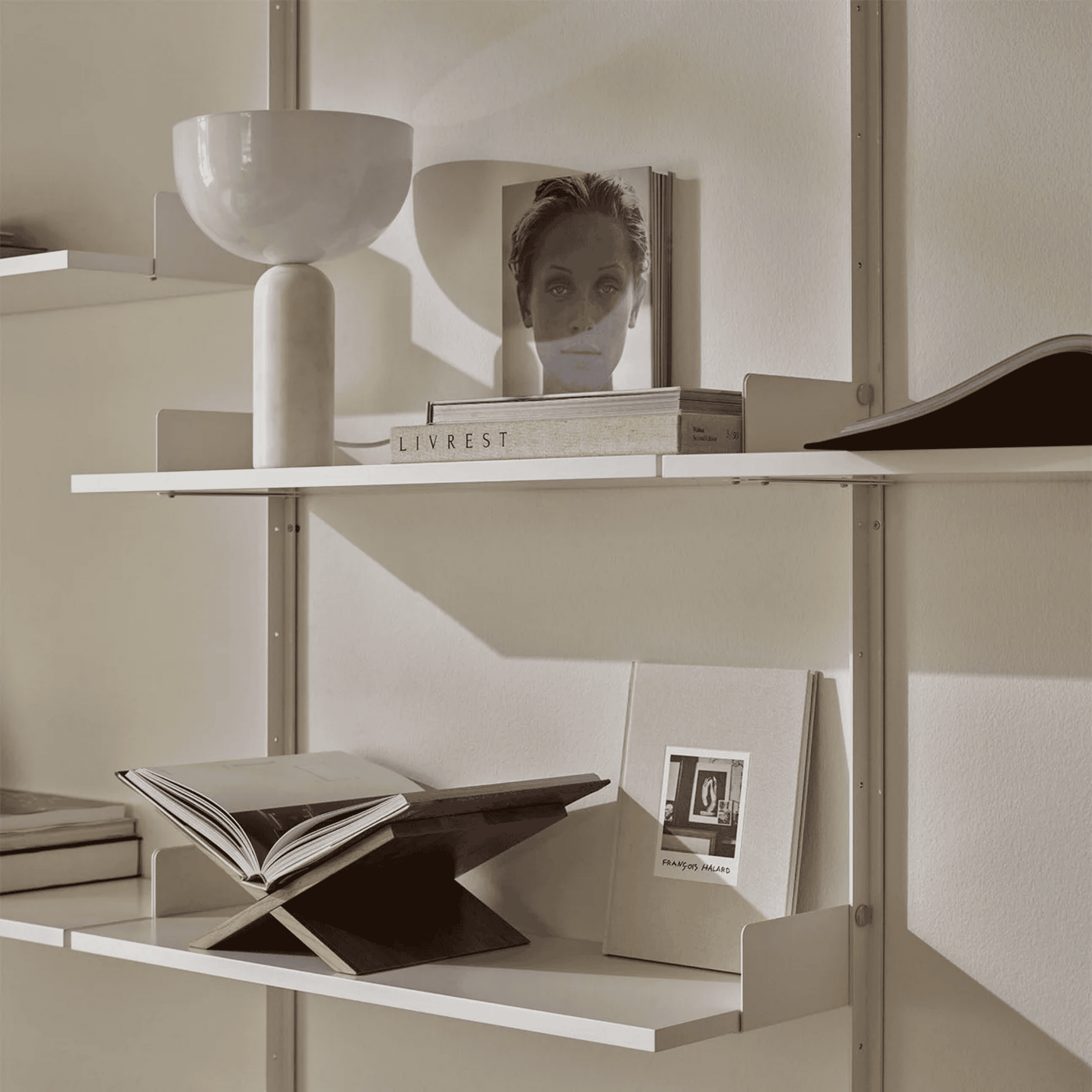Shelving unit with books and decorative items against a neutral wall