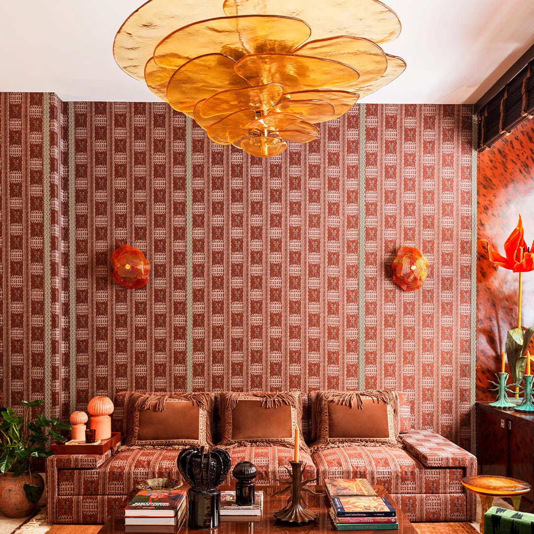 Living room with patterned wallpaper, floral chandelier, and decorative items.