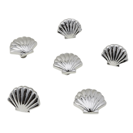 Set of six silver shell-shaped coasters on a white background