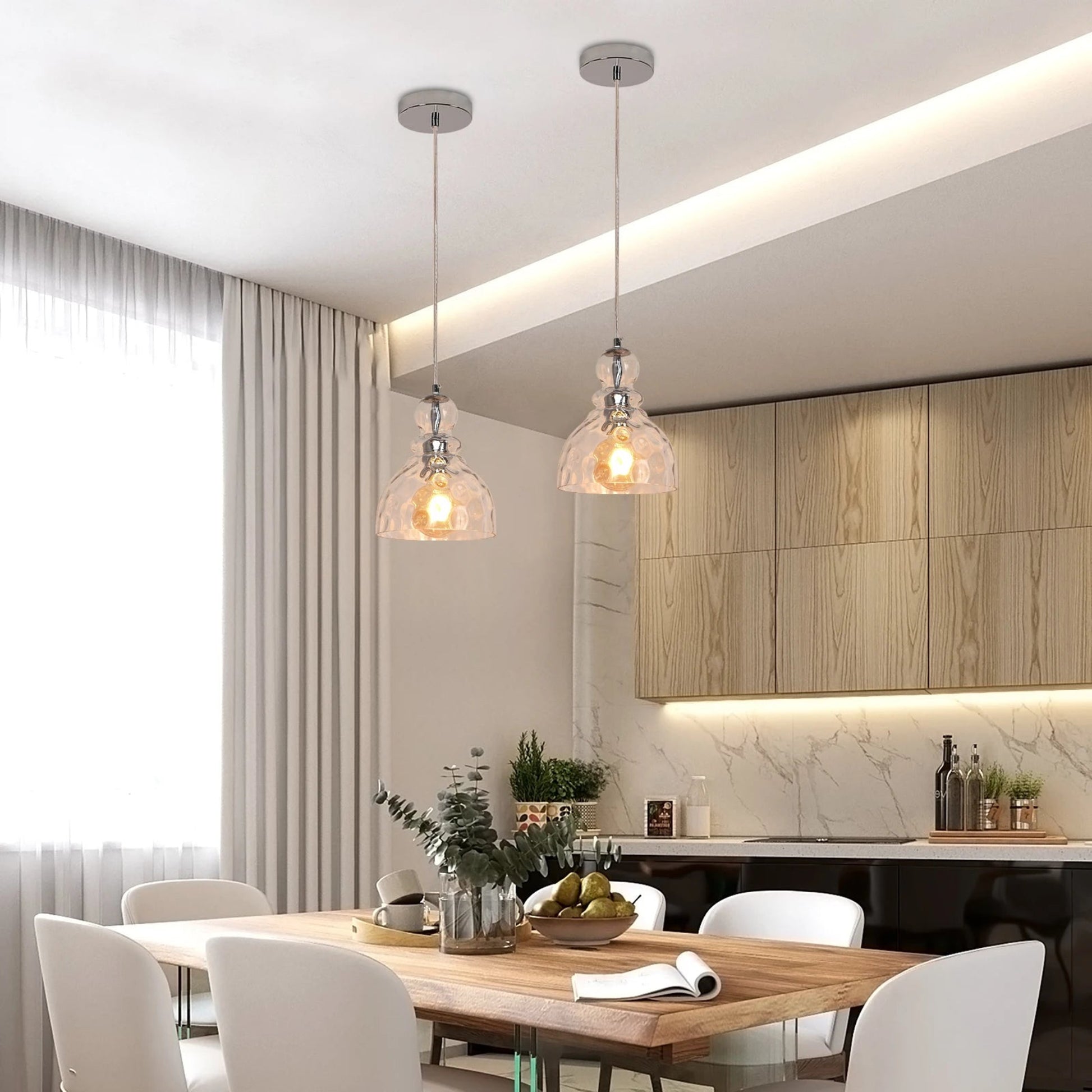 Modern kitchen with wooden dining table and chairs, pendant lights, and kitchen counter.
