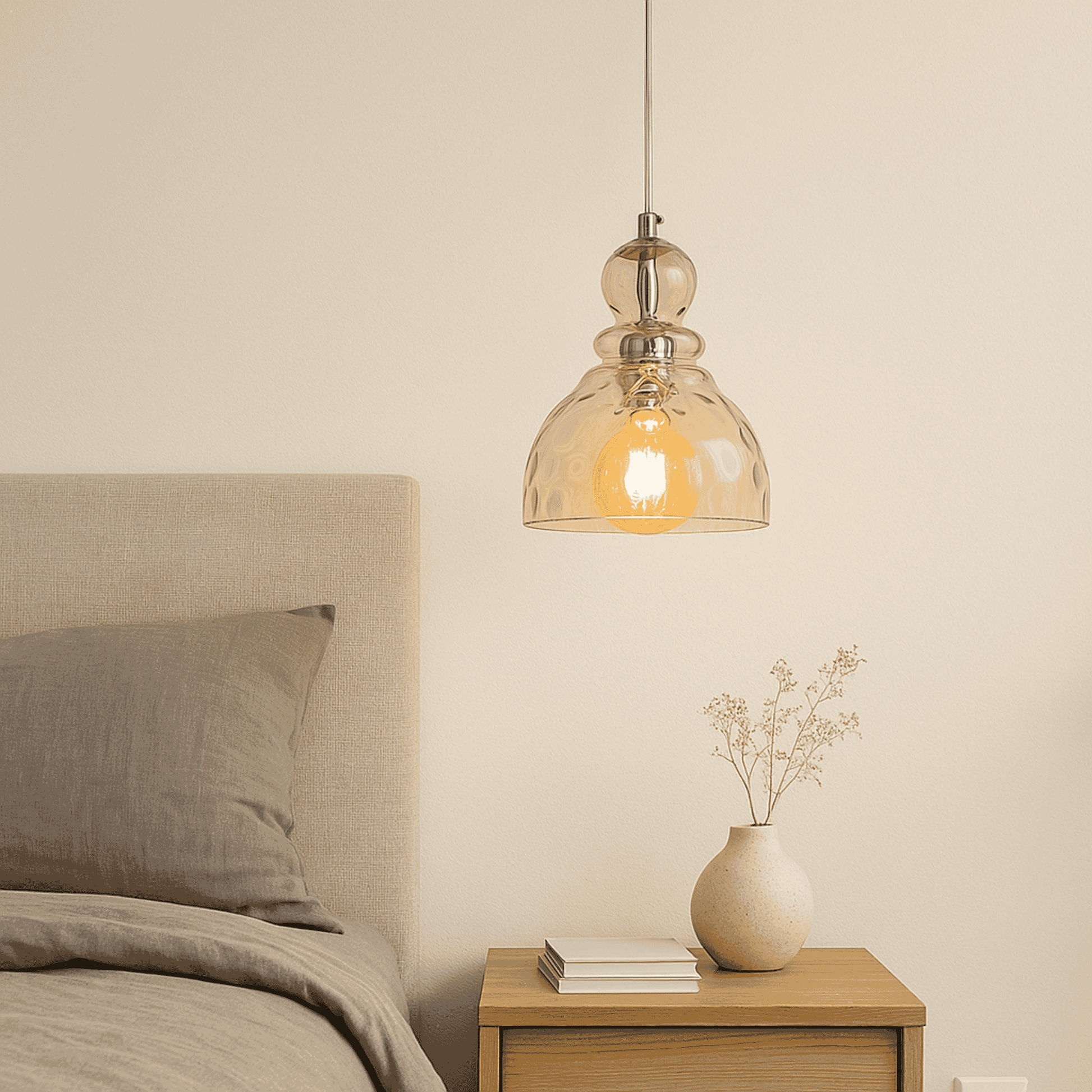 Bedroom with a pendant light, vase, and books on a nightstand.