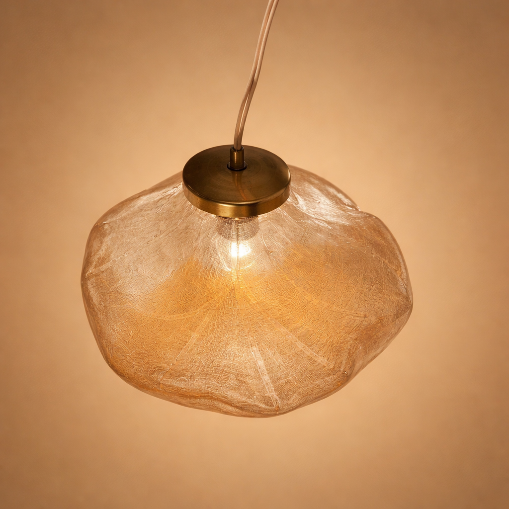 Amber glass pendant light against a beige background