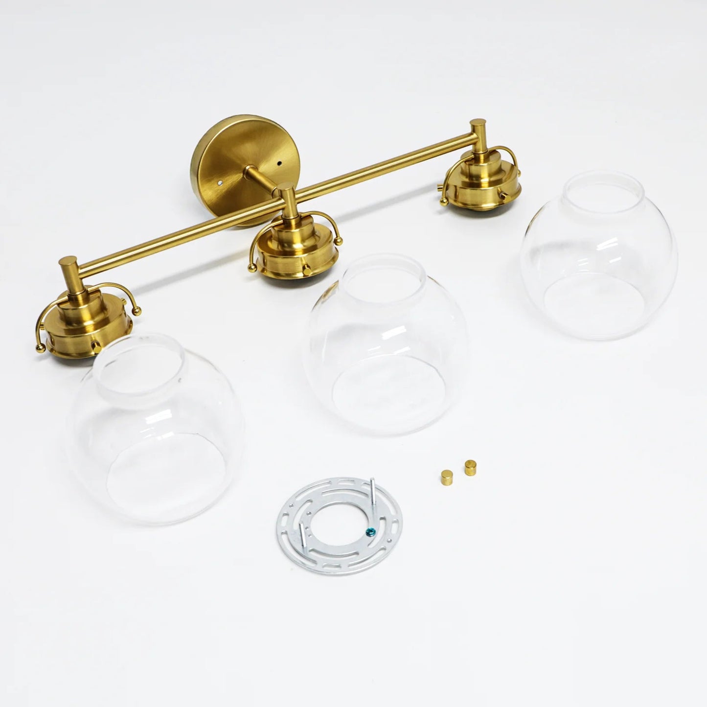 Brass wall-mounted light fixture with glass shades on a white background