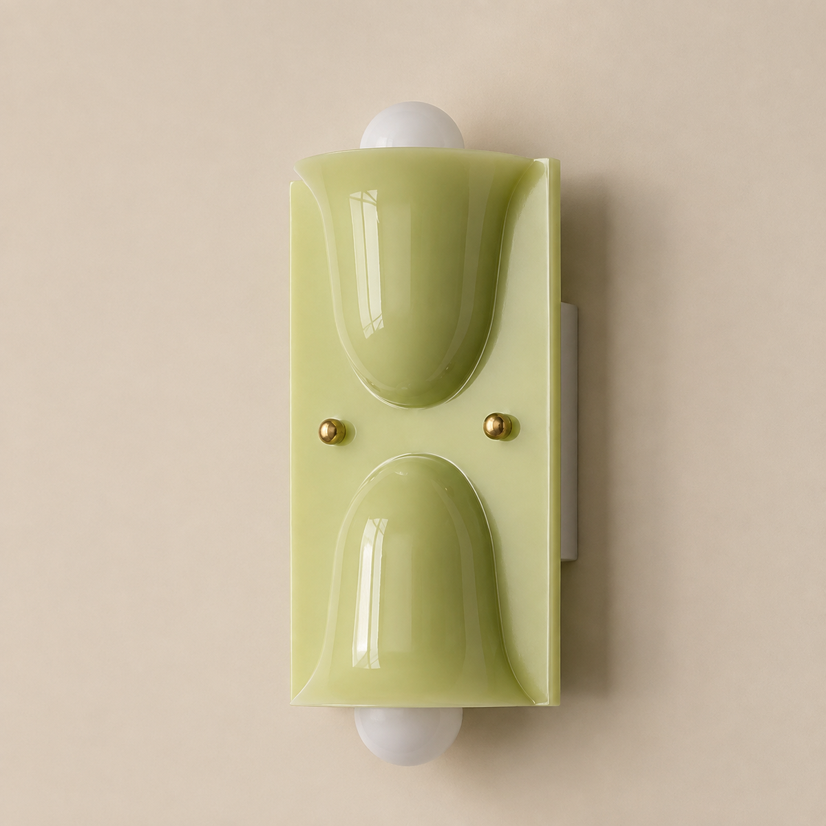 A modern wall-mounted light fixture with a glossy pale yellow-green acrylic shade, featuring two dome-shaped panels and small gold-toned screws, shown against a solid beige background.