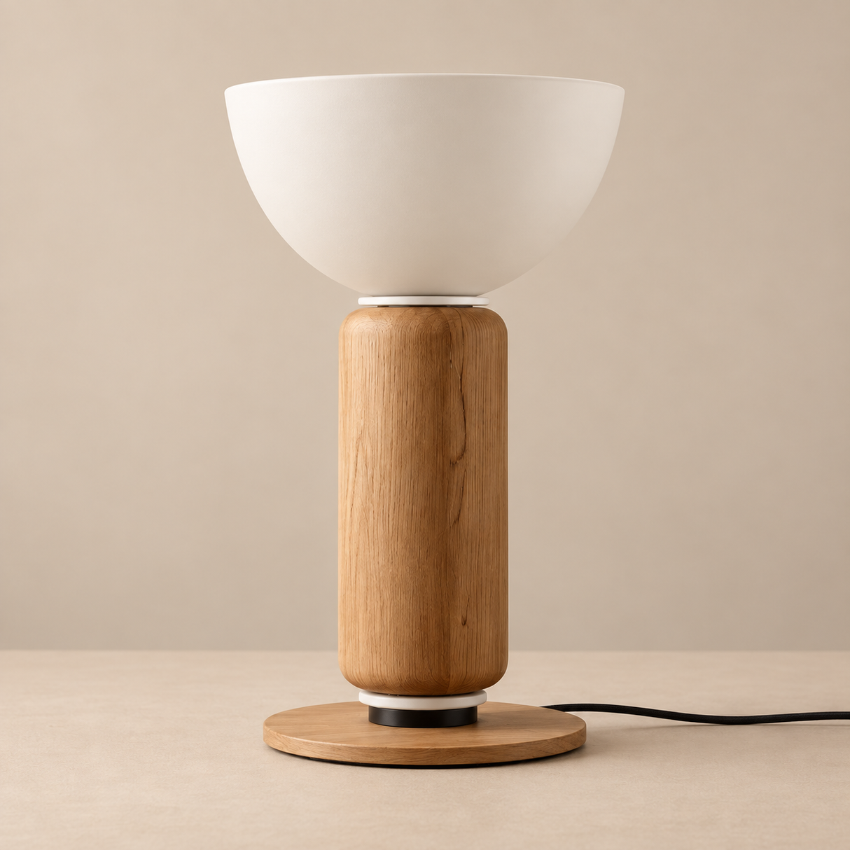 A modern table lamp with a matte white bowl-shaped shade, a cylindrical natural oak wood base, and a round wooden foot ring, shown on a matching beige surface against a neutral beige background.