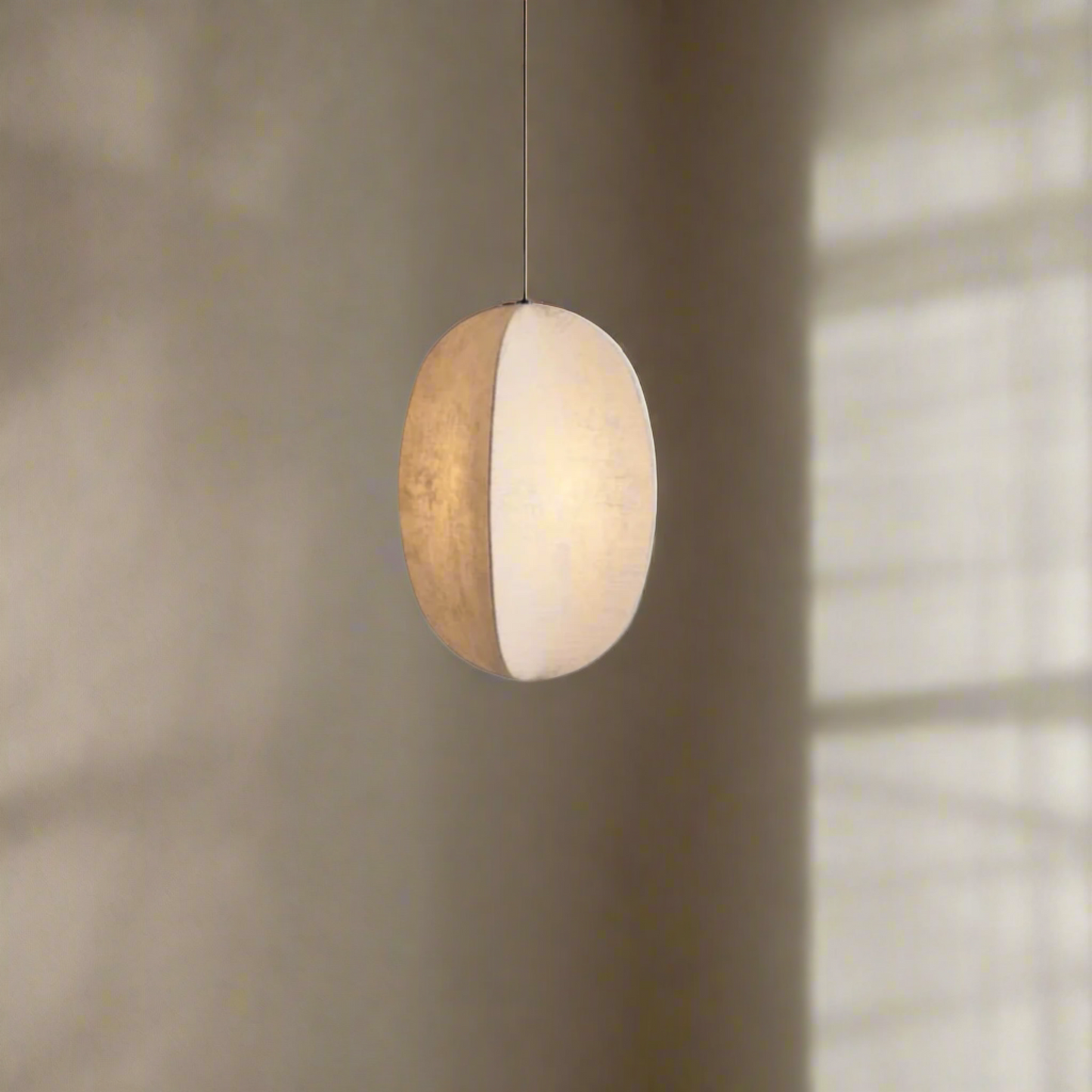 Spherical pendant light with a white shade on a white background