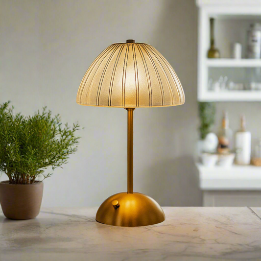 Gold table lamp with a textured shade on a white background