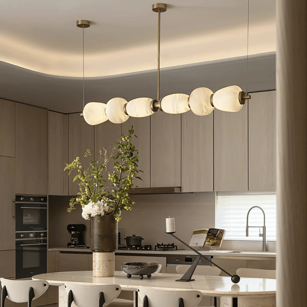 Modern kitchen with a chandelier, vase with flowers, and kitchen appliances.