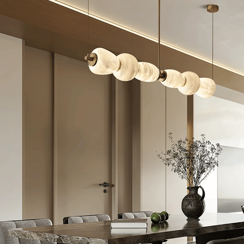 Modern pendant light fixture hanging above a dining table in a stylish interior setting.