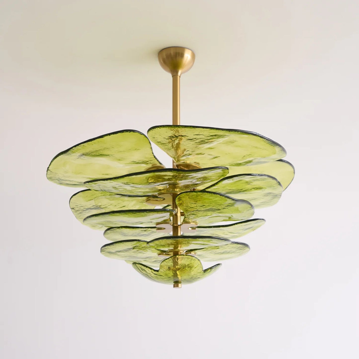Green glass chandelier with gold fixture on a white background