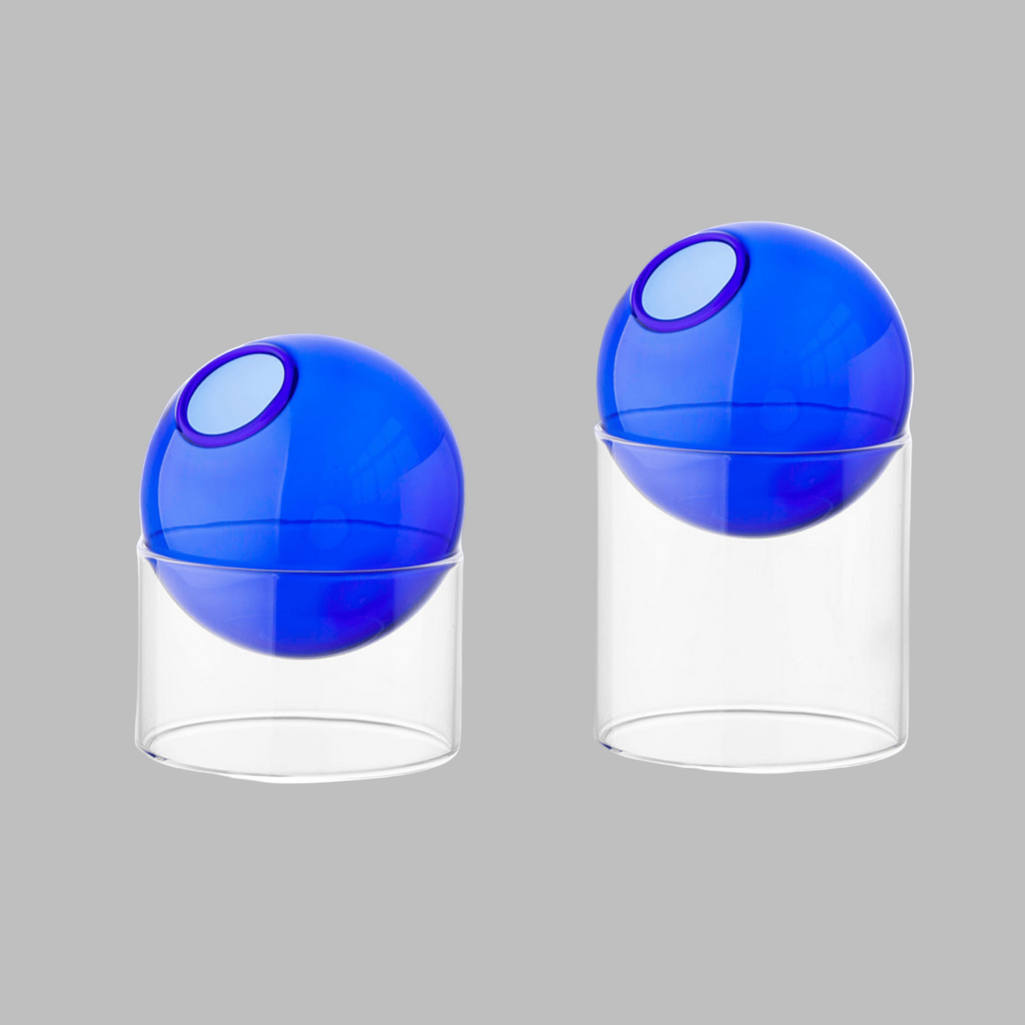 Two blue and clear spherical containers on a white background