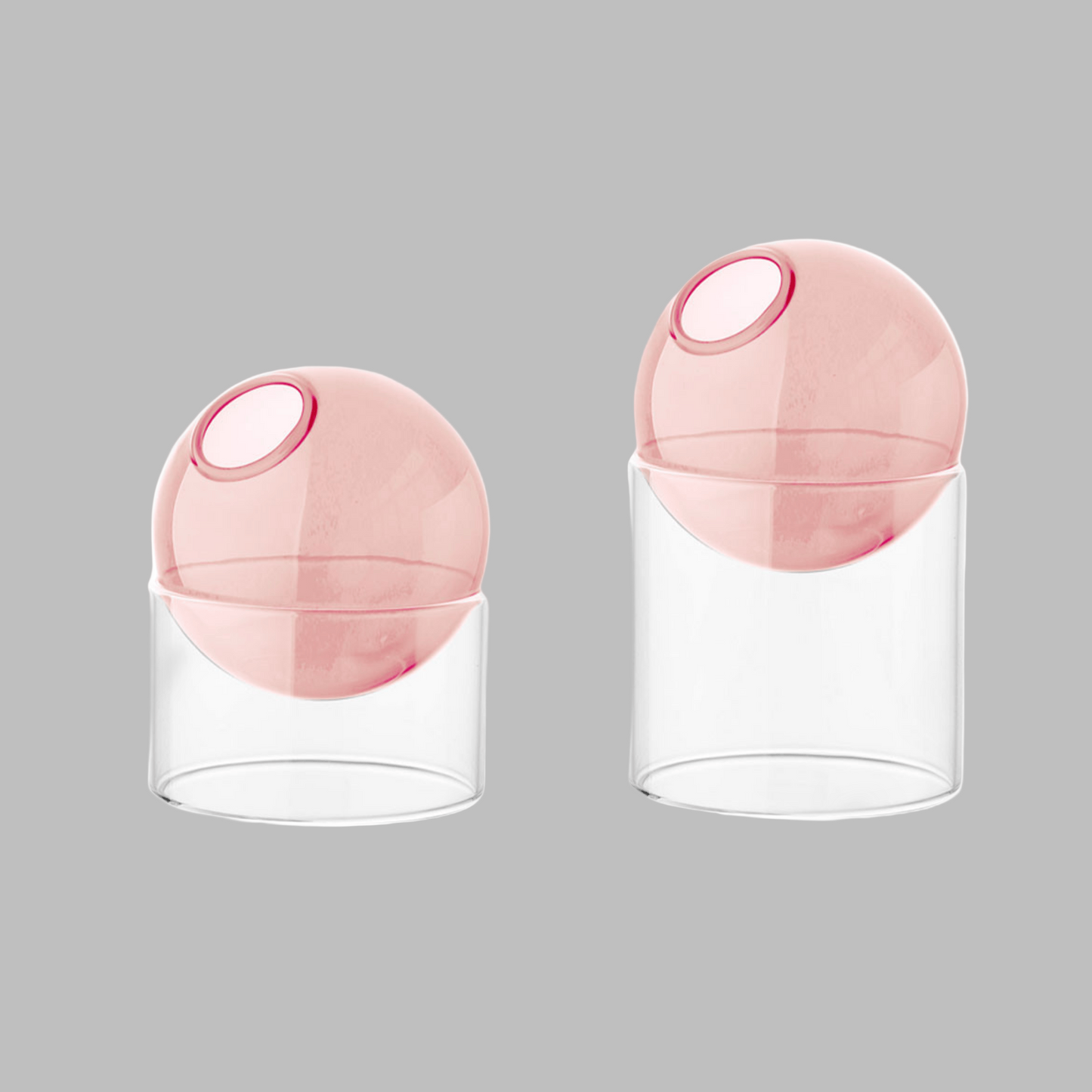 Two pink spherical containers with clear bases on a white background