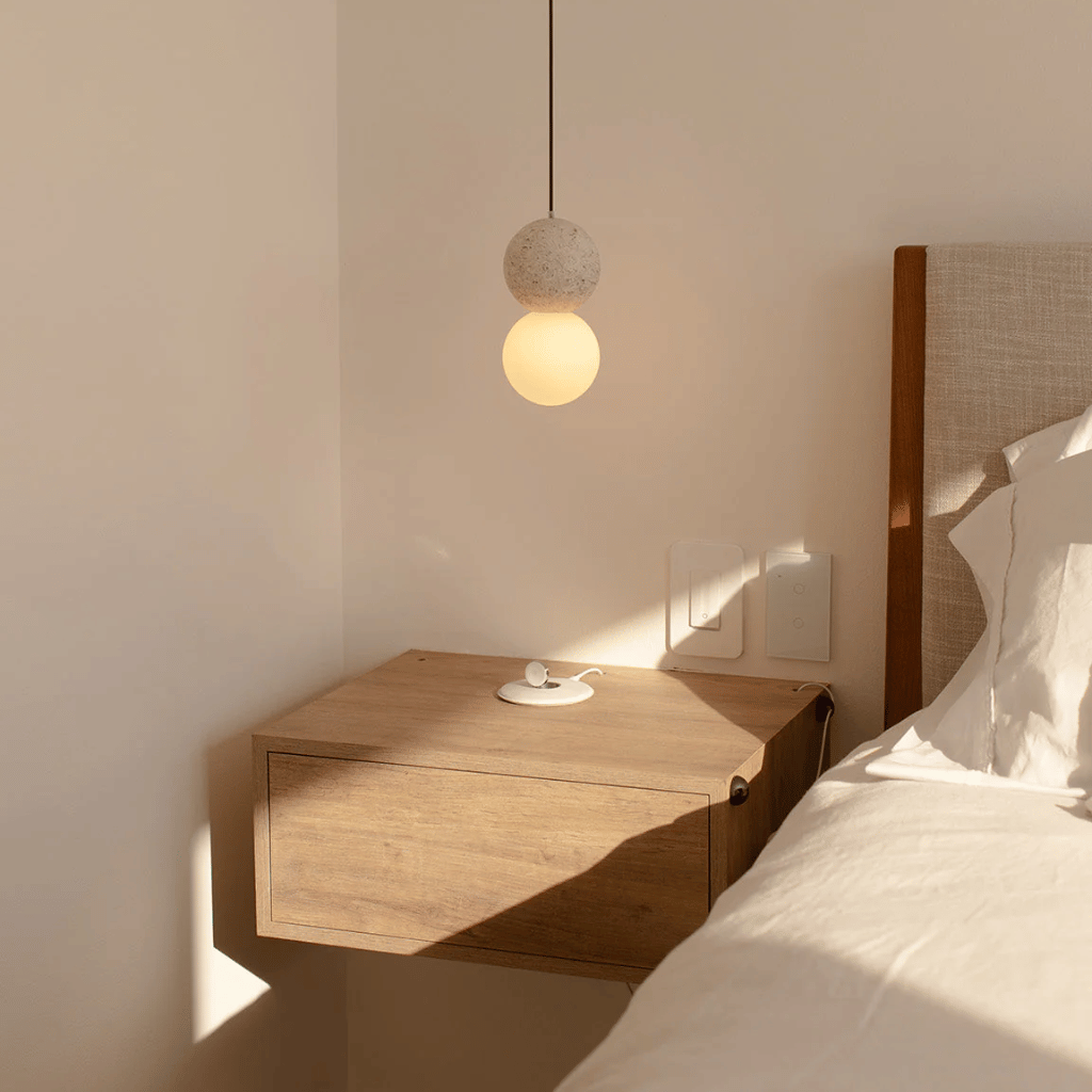 Wooden nightstand with a lamp in a bedroom setting