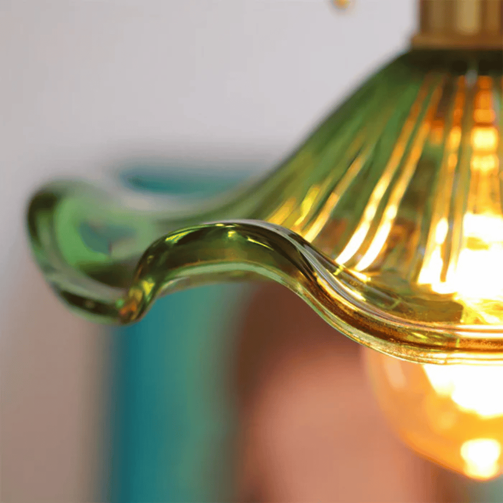 Close-up of a green glass wall sconce with a blurred background