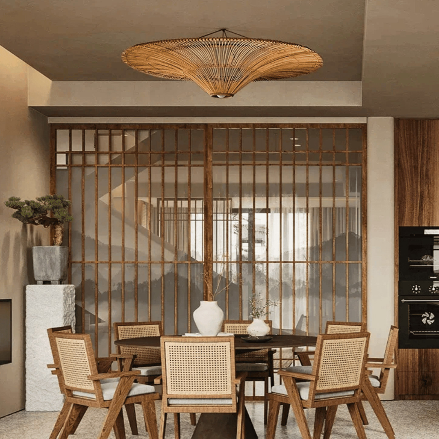 Dining area with wooden chairs, table, and decorative elements in a modern interior setting.