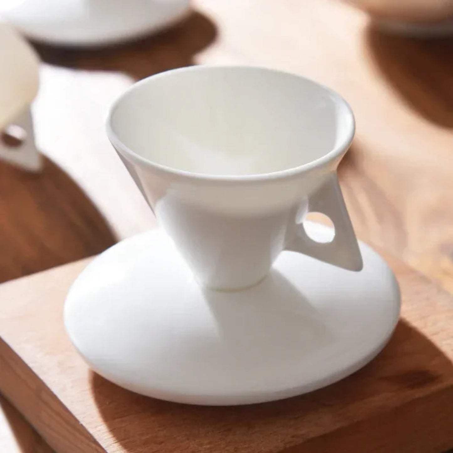 White ceramic cup with handle on a wooden surface
