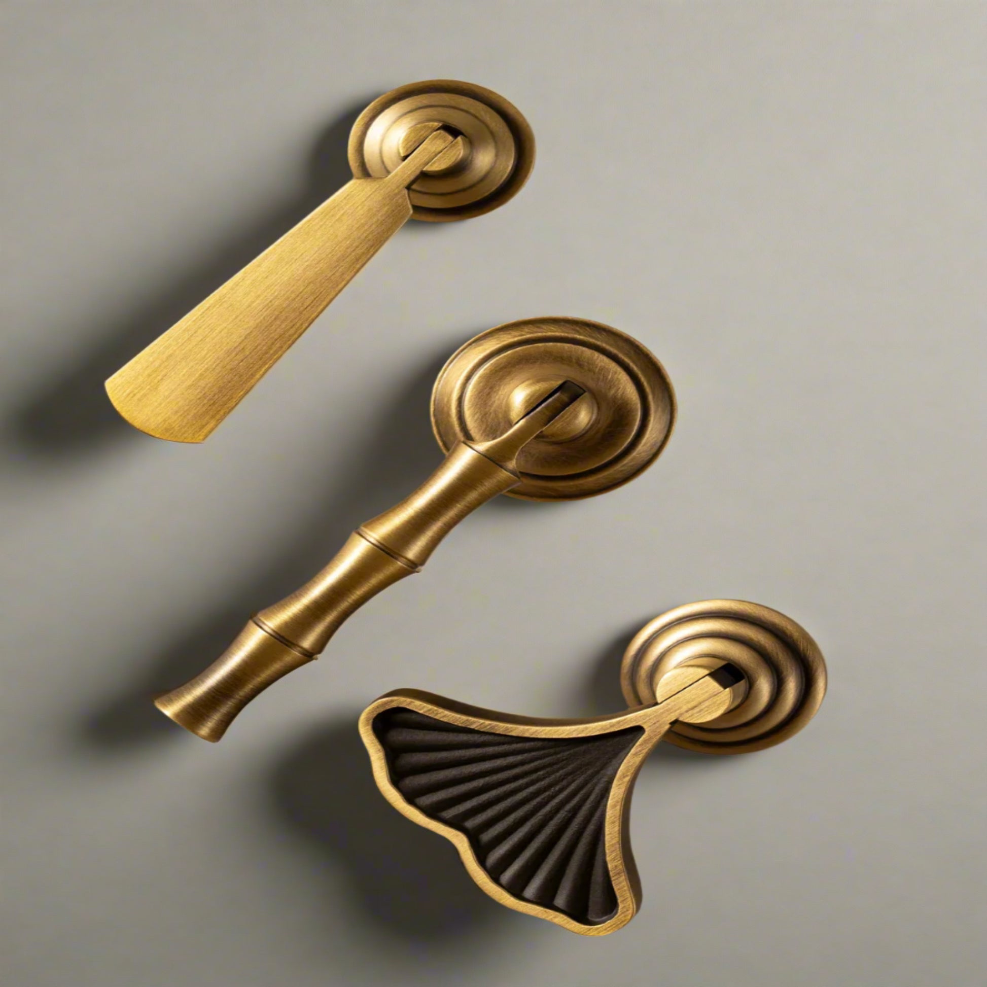 Set of gold door handles and a black decorative knob on a beige background