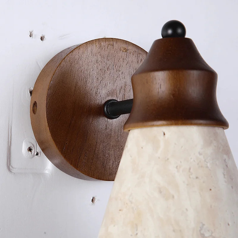 Wooden wall sconce with a ceramic shade on a white wall.