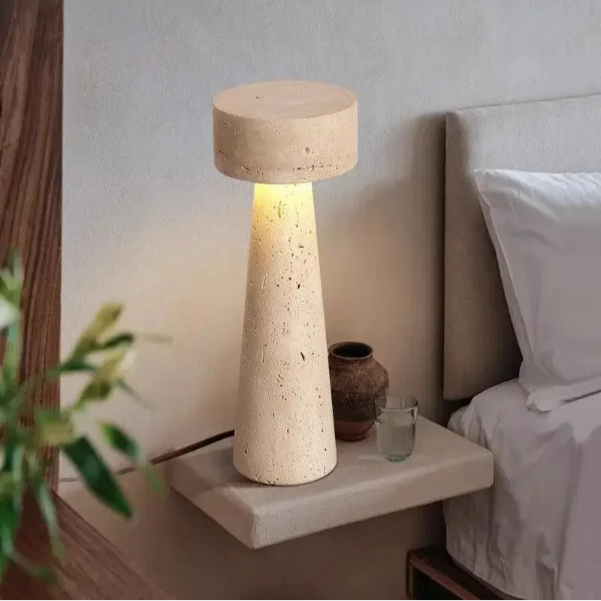 Concrete table lamp on a nightstand next to a bed