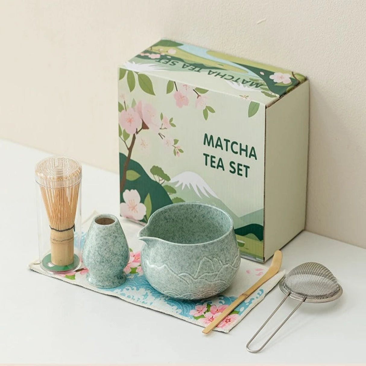 Matcha tea set with a green box featuring matcha-themed illustrations on a white surface.