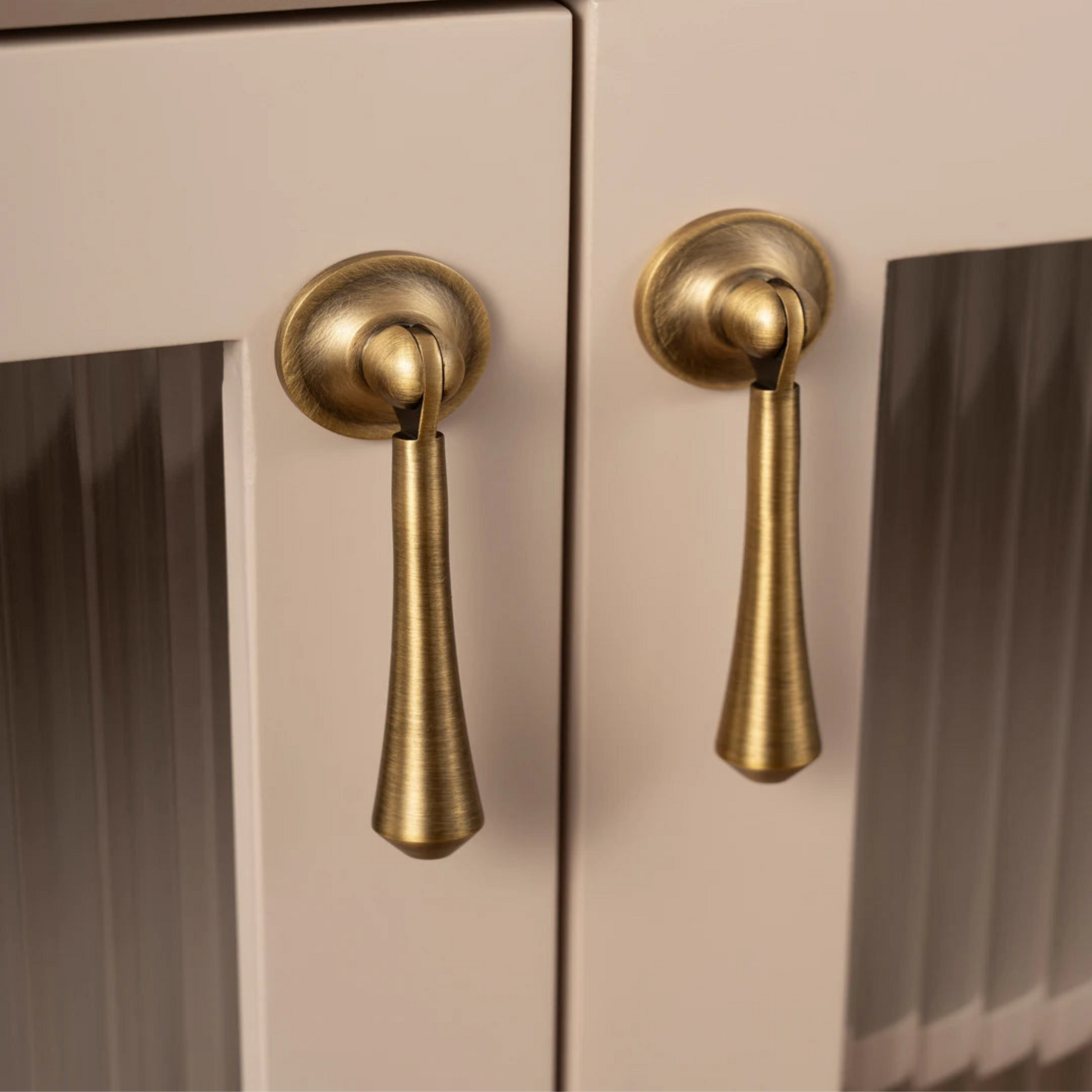 Cabinet doors with gold handles on a beige background