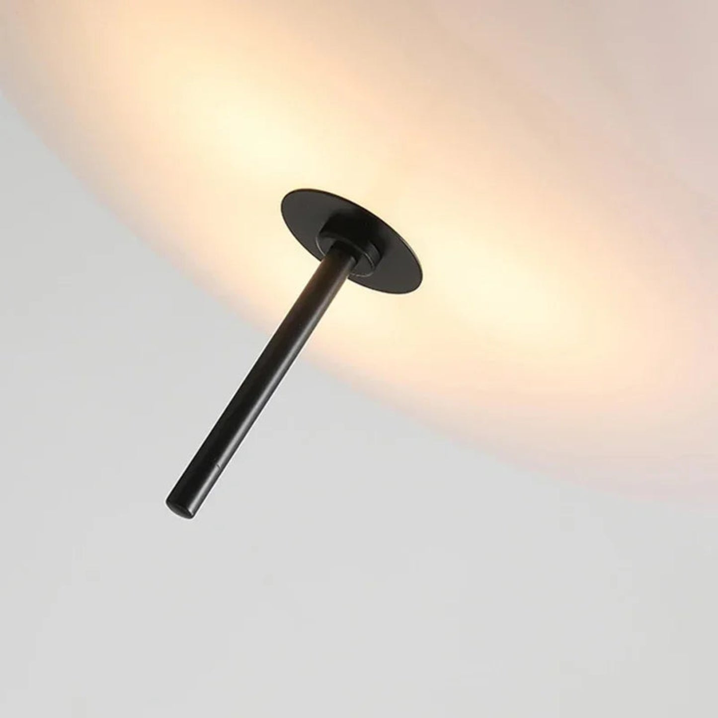 Modern wall light fixture with a black finish on a neutral background