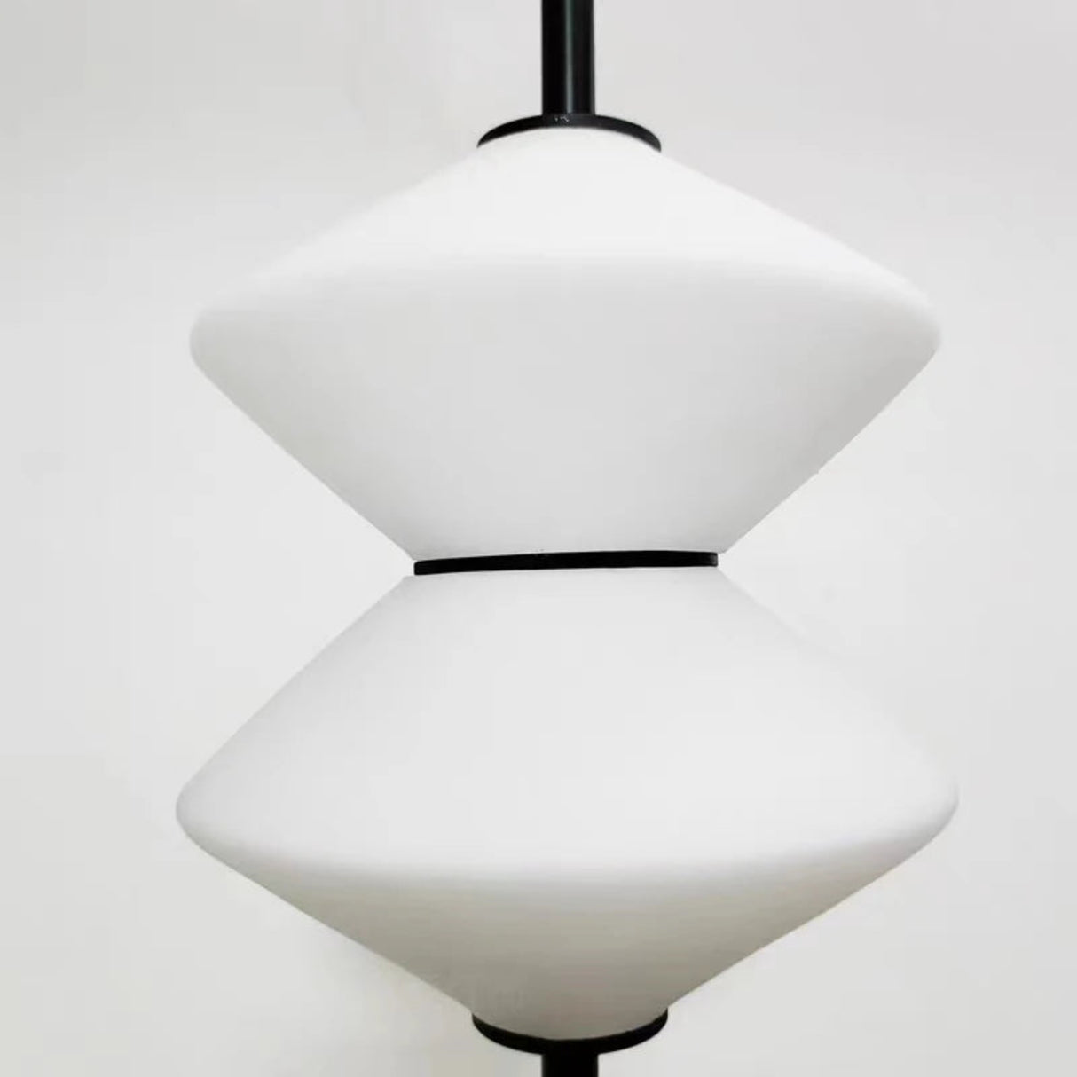 Modern pendant light with white glass shades on a plain background