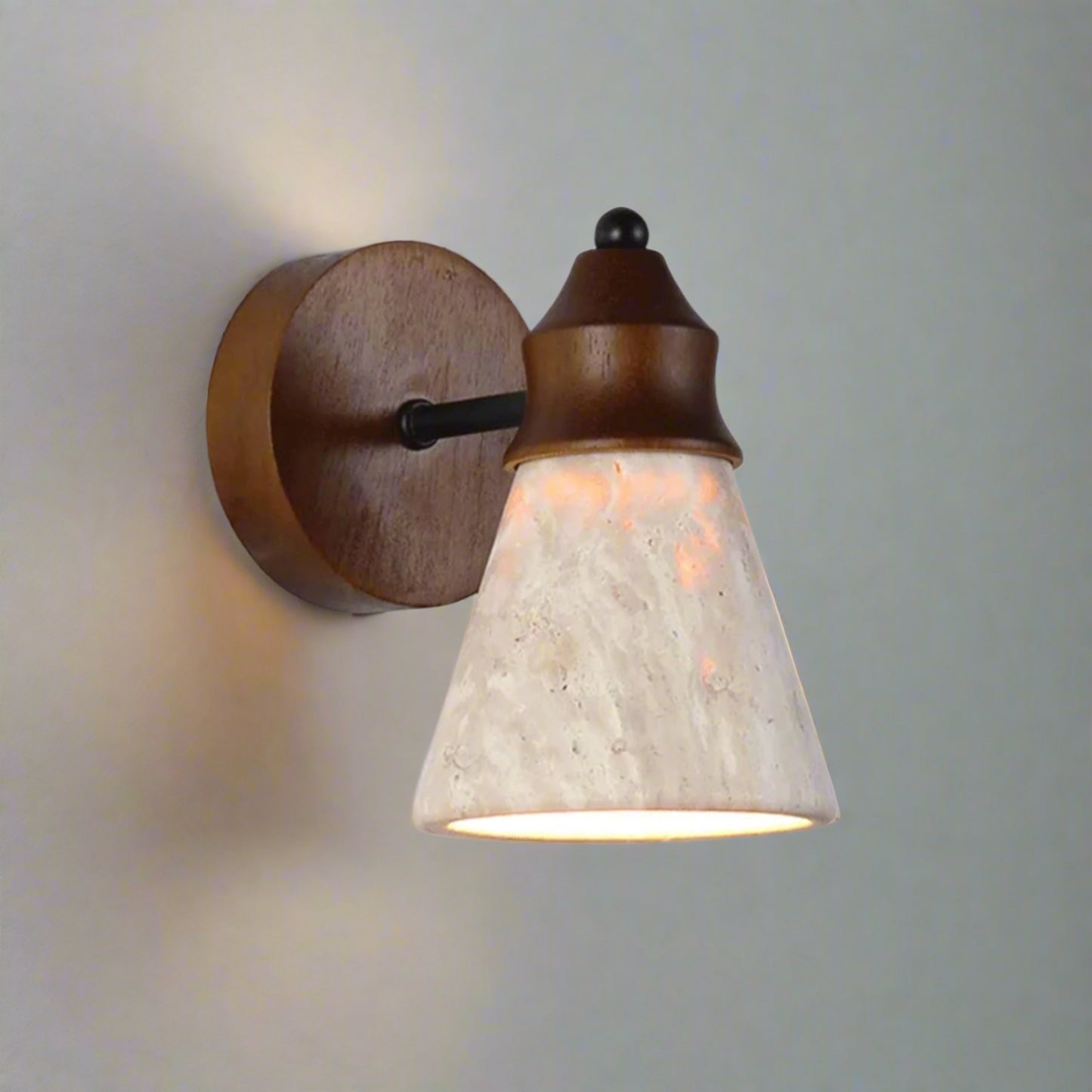 Wall-mounted light fixture with wooden base and stone-like shade on a white background