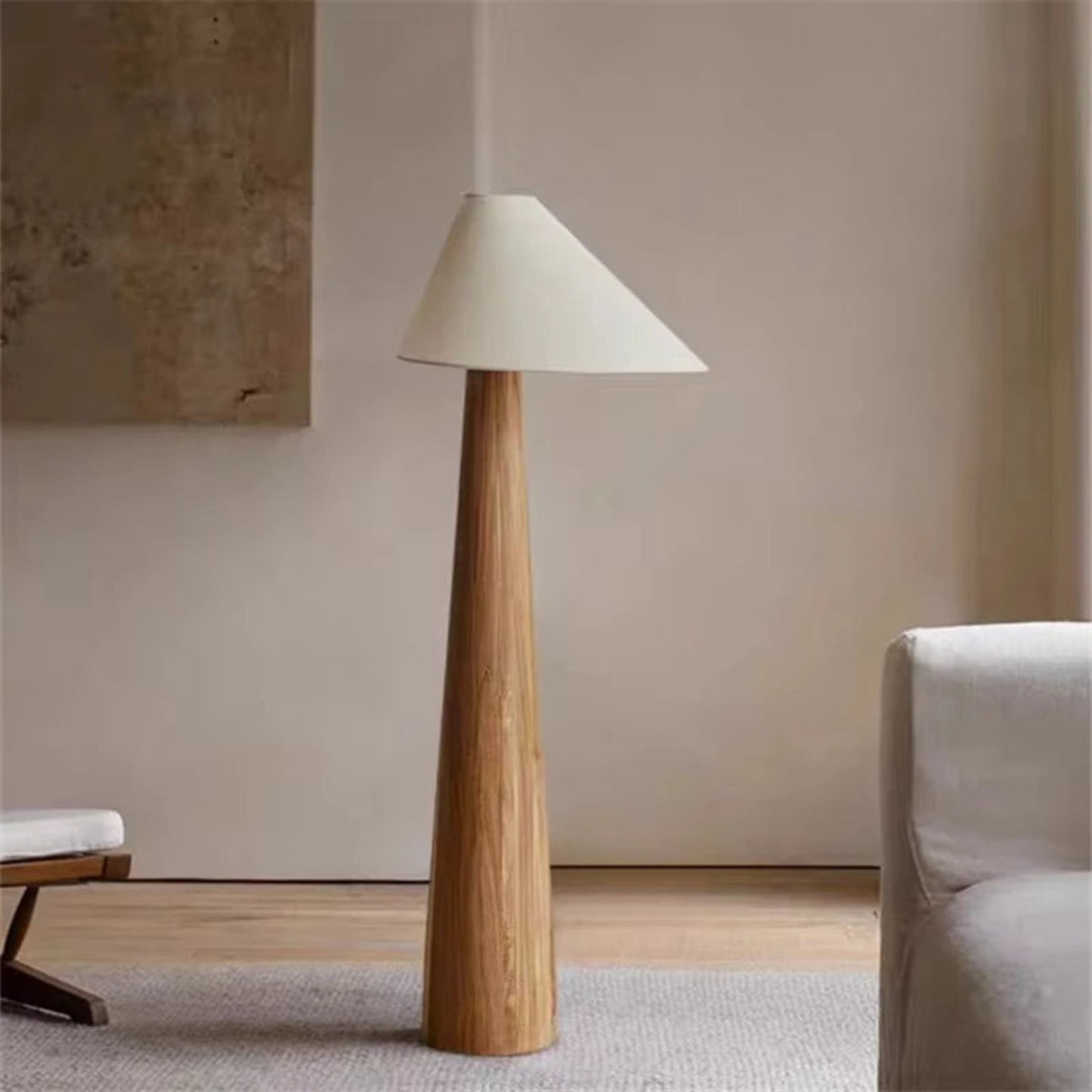 Floor lamp with wooden base and white shade in a minimalistic room.