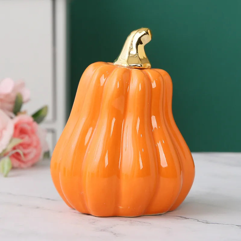 Decorative orange pumpkin with a gold stem on a marble surface.