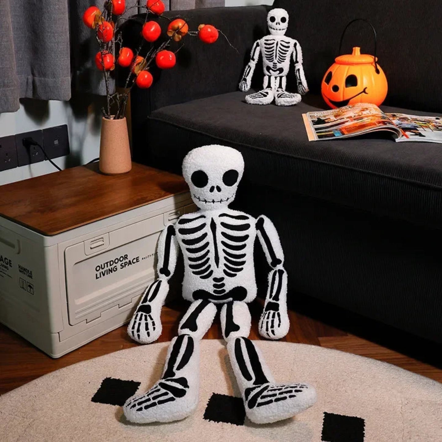 Halloween-themed room with plush skeleton toy, pumpkins, and decorations on a couch.