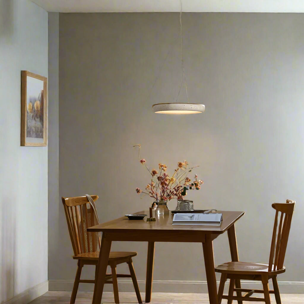 Dining area with wooden table and chairs, pendant light, and plants.
