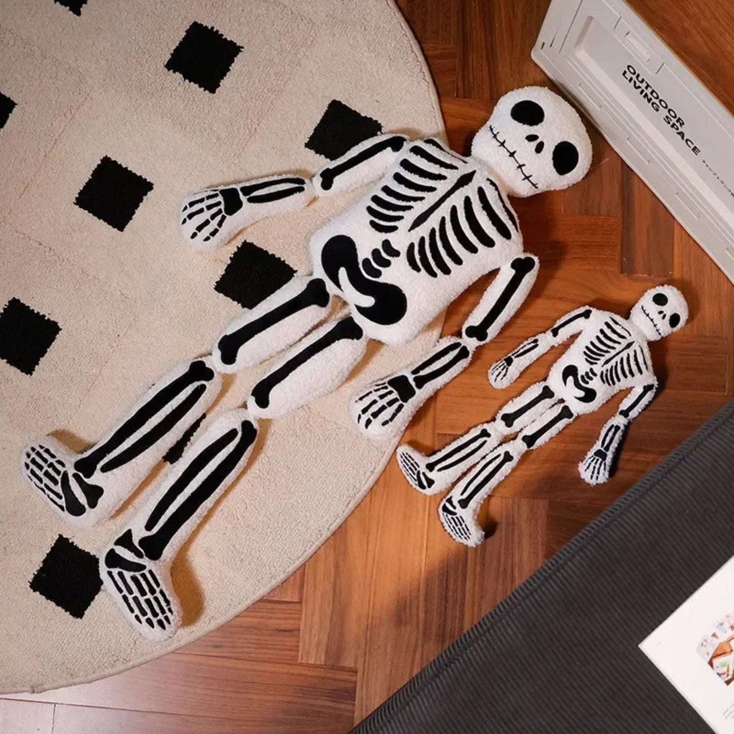 Plush skeleton toys on a wooden floor with a rug featuring black squares.
