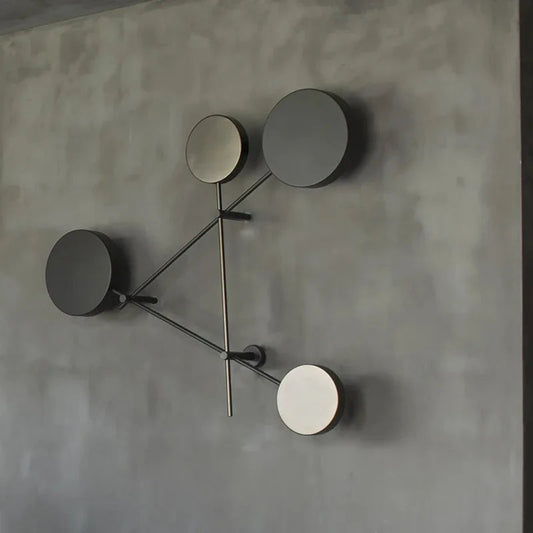 Modern wall clock with four circular faces on a gray wall