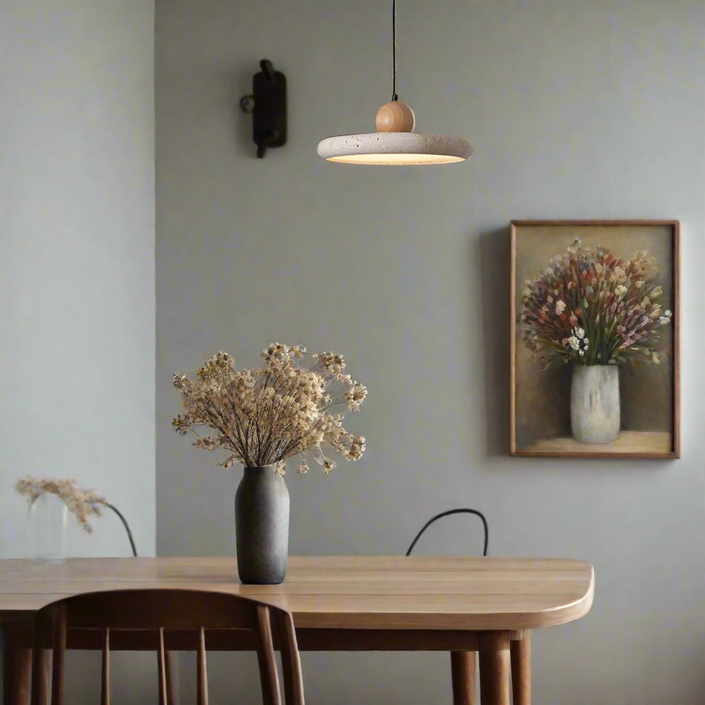 Modern dining area with a table, chairs, and a pendant light in a minimalistic setting.