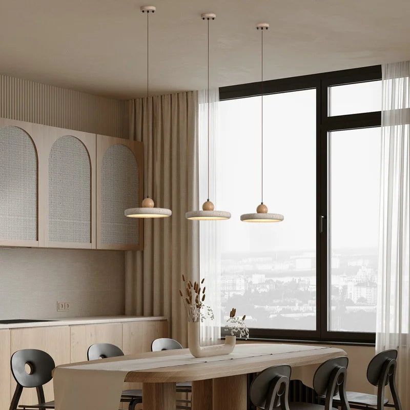Modern kitchen with pendant lights, large window, and wooden dining table.