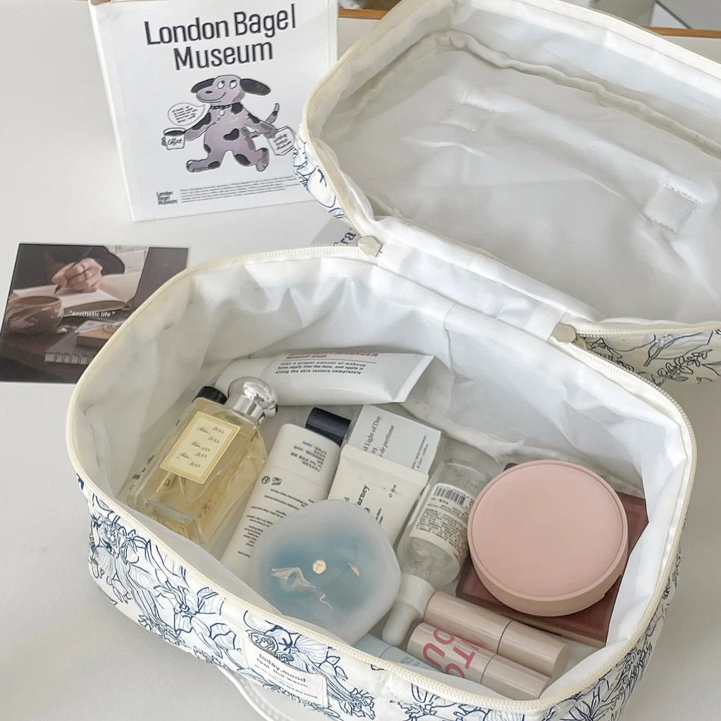 Cosmetic bag with skincare products on a table with a magazine in the background