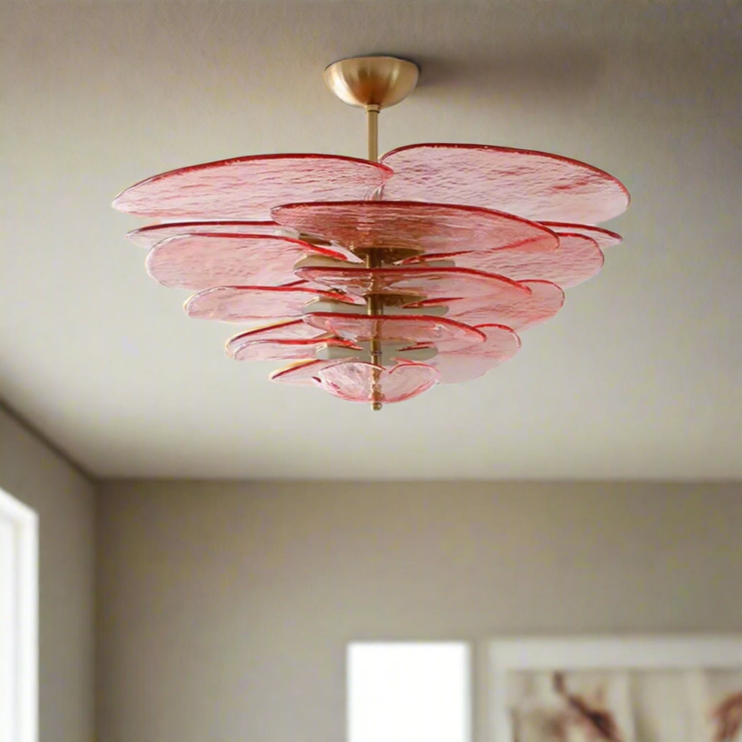 Pink chandelier with gold fixture against a white wall