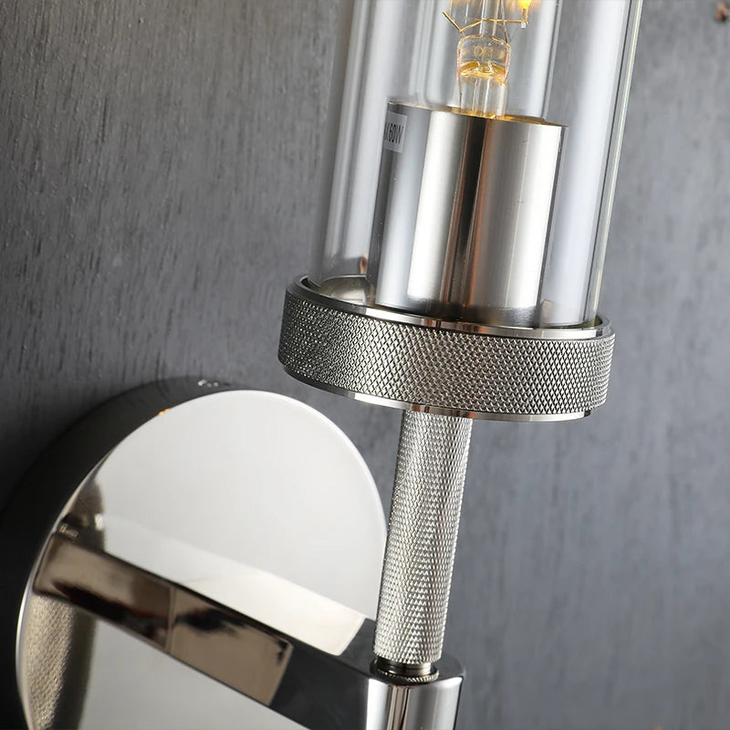 Close-up of a modern wall-mounted light fixture with metallic and glass design.