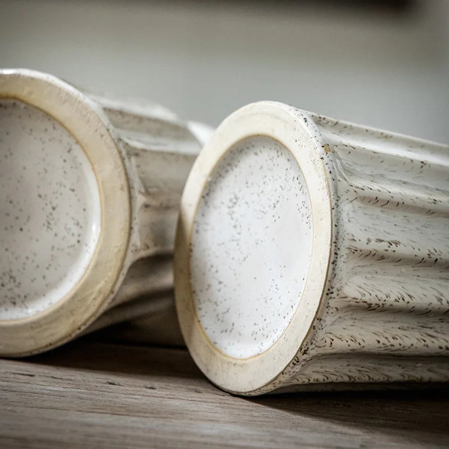 Close-up of two ceramic bowls with textured surfaces on a wooden surface.