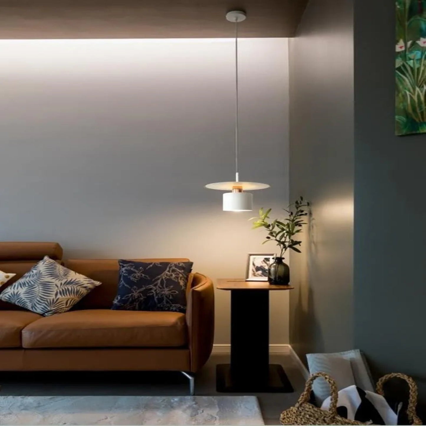 Modern living room with a brown sofa, decorative pillows, and a pendant light.
