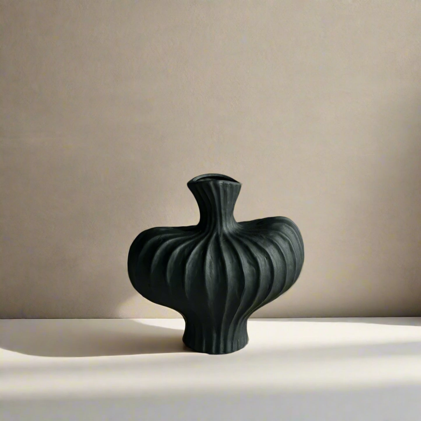 Black textured vase on a white surface