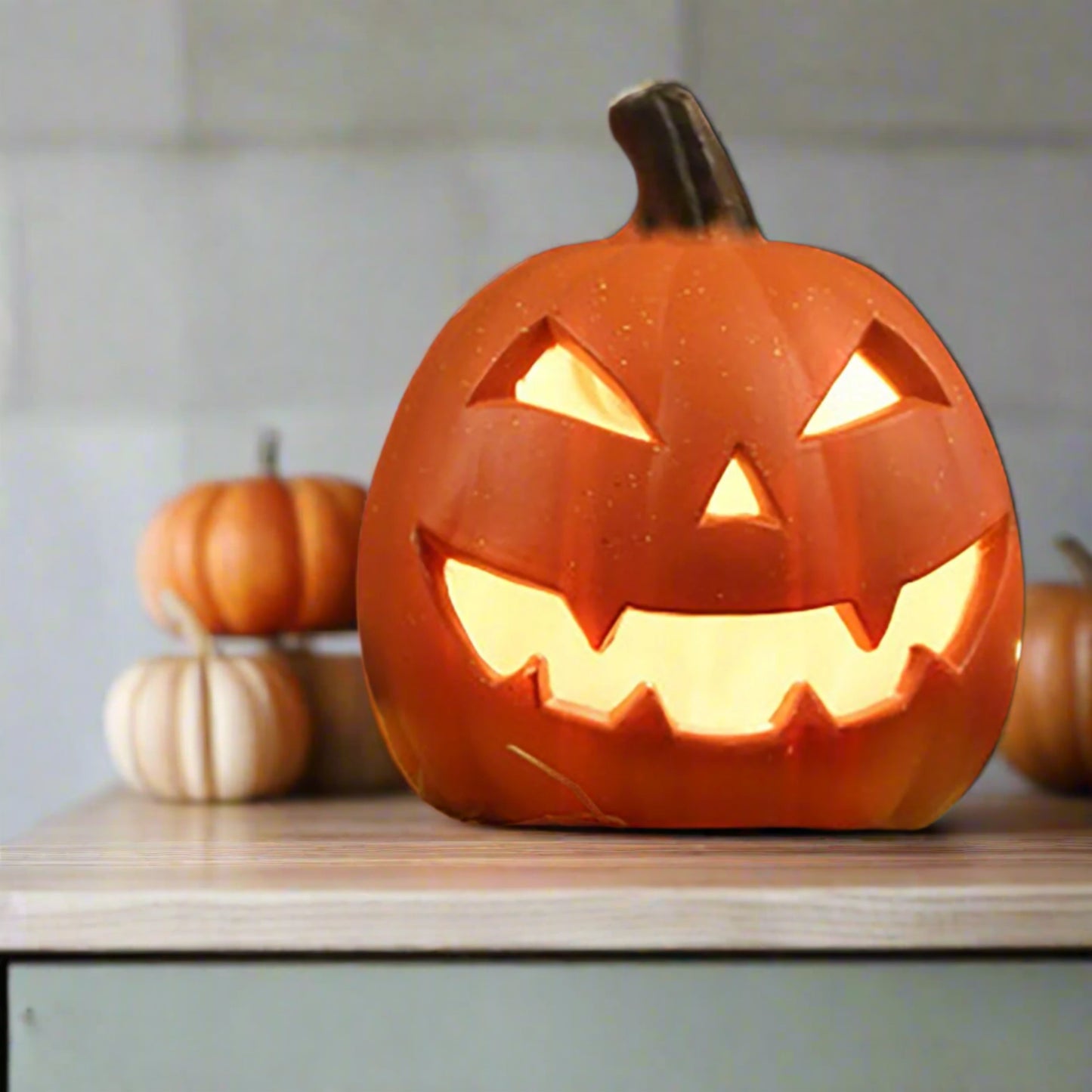 Carved pumpkin with glowing interior on hay against a dark background