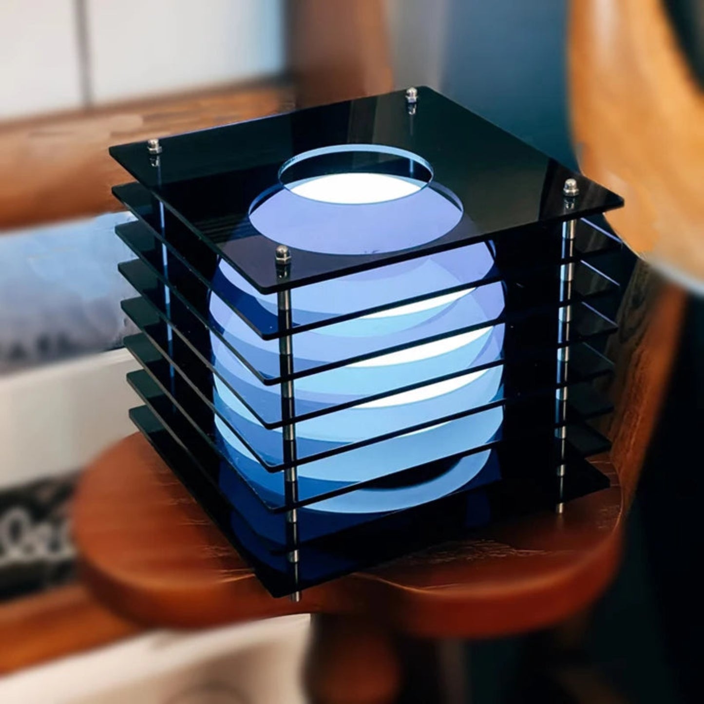 Modern black and blue geometric lamp on a wooden surface