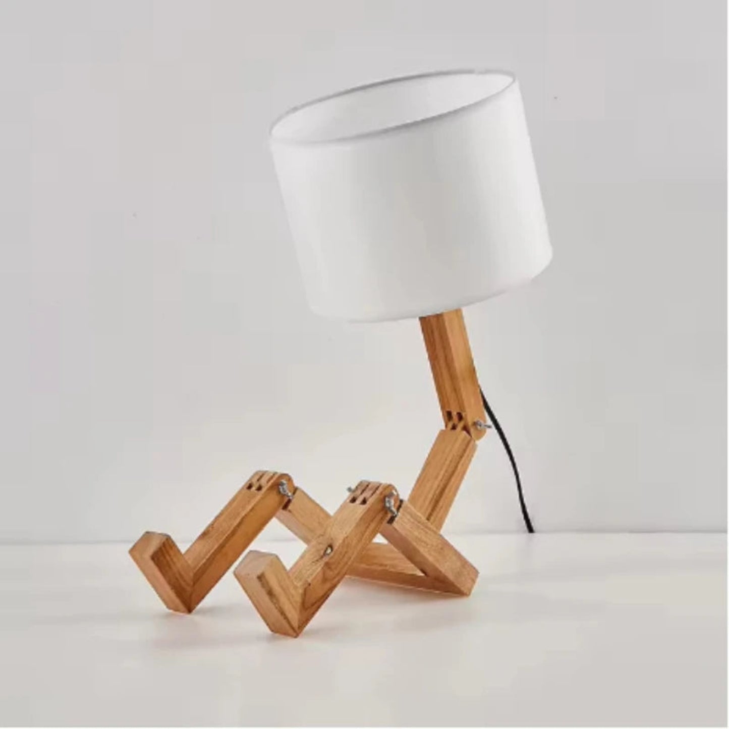 Table lamp with wooden base and white shade on a light gray background