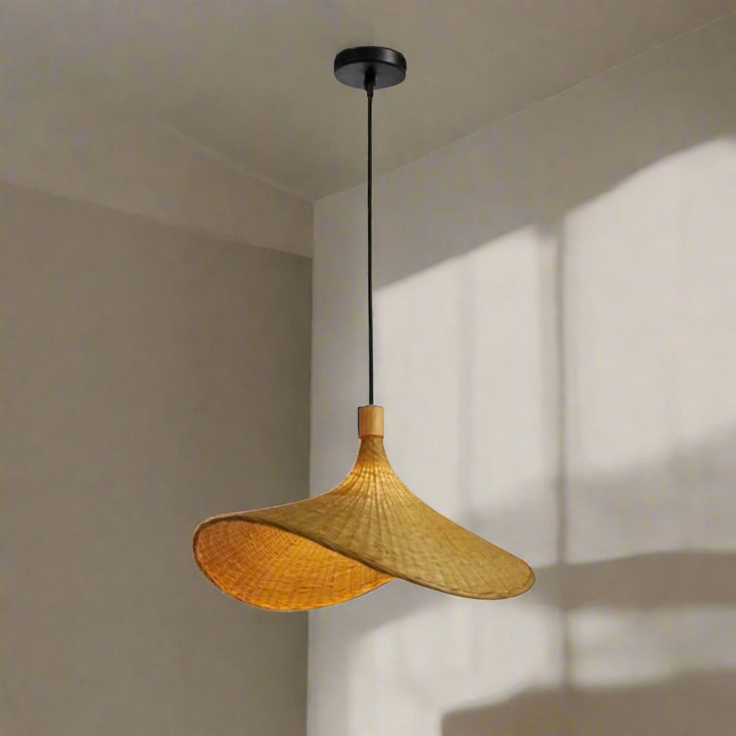 Pendant light with black base and wicker shades on a neutral background.